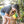 Load image into Gallery viewer, P.L.A.Y. Tropical Paradise Collection - Paws Up Pineapple Toy in dog&#39;s front paws being held up and kissed by dog mom in a tropical beach forest
